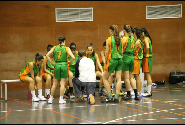 Jugadoras del Proa Construye CBF Huesca reciben instrucciones de su entrenador, Antonio Luna.
