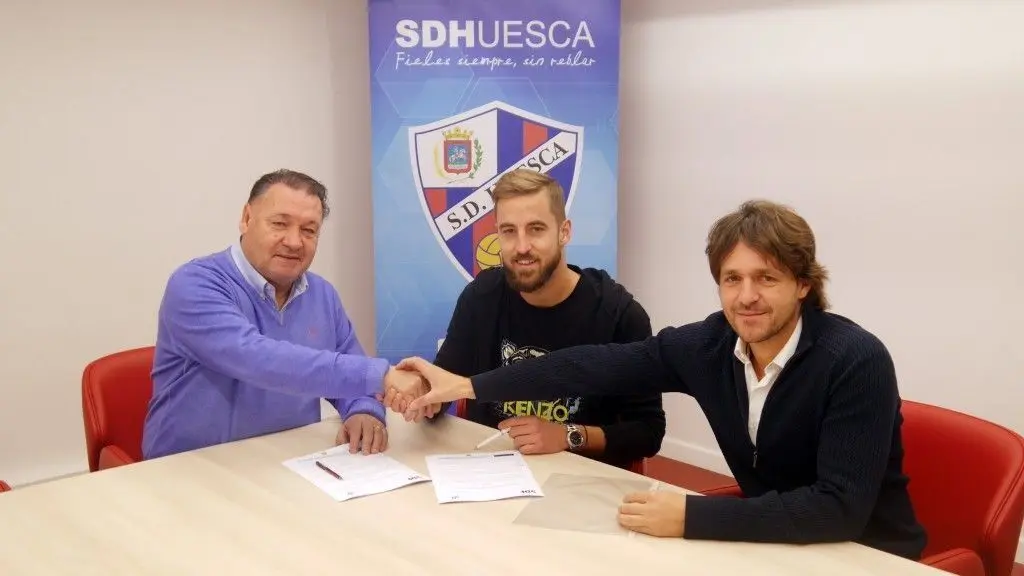 Jorge Pulido junto a Agust&iacute;n Lasaosa y Josete Ortas en el momento de la firma. |Foto: SDHuesca