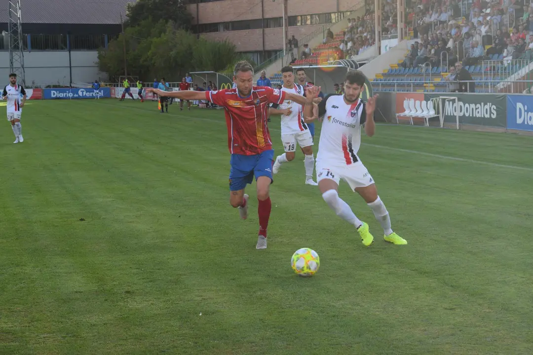 Bravo pelea un bal&oacute;n con To&ntilde;o en el partido entre el CD Teruel y el Villanueva CF | Foto: Isabel Traver