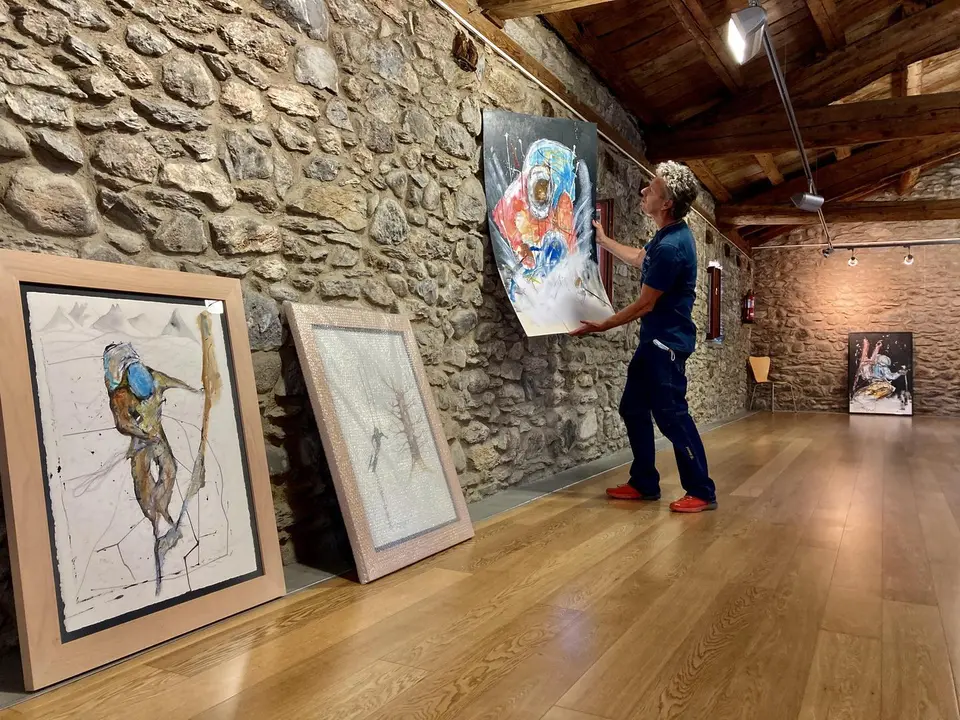 Ricardo Montoro cuelga uno de los cuadros de la exposici&oacute;n que hasta el d&iacute;a 10 est&aacute; en el Palacio de los Condes de Ribagorza de Benasque. Foto: Cedida