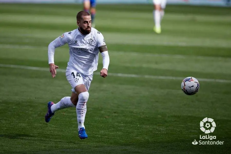 El capit&aacute;n del Huesca, Jorge Pulido, busca el bal&oacute;n contra el Eibar. | Foto: LaLiga