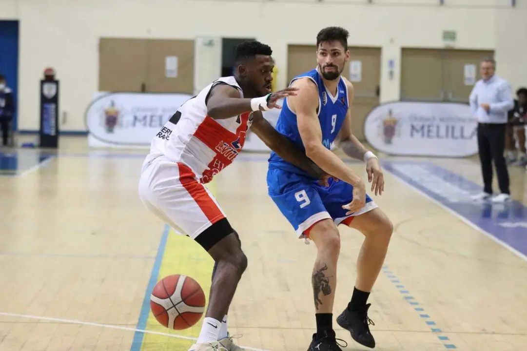 Mike Moore, en una acci&oacute;n defensiva en el partido contra Melilla y con &Oacute;scar Lata al fondo. Foto: Melilla Sport Capital