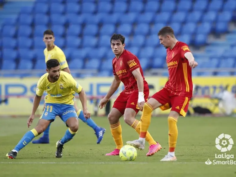 Benito pelea un bal&oacute;n con Zanimacchia ante la mirada de Iv&aacute;n Az&oacute;n en un lance del &uacute;ltimo Las Palmas-Real Zaragoza. | Foto: Real Zaragoza