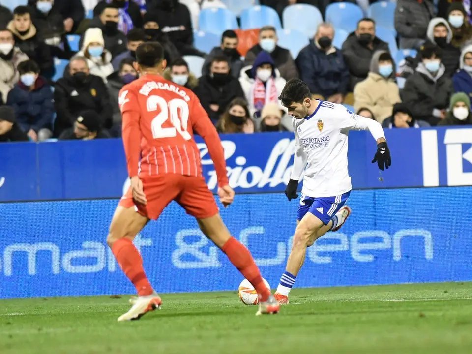 Miguel Puche busca el centro ante la oposici&oacute;n de Diego Carlos | Foto: Real Zaragoza