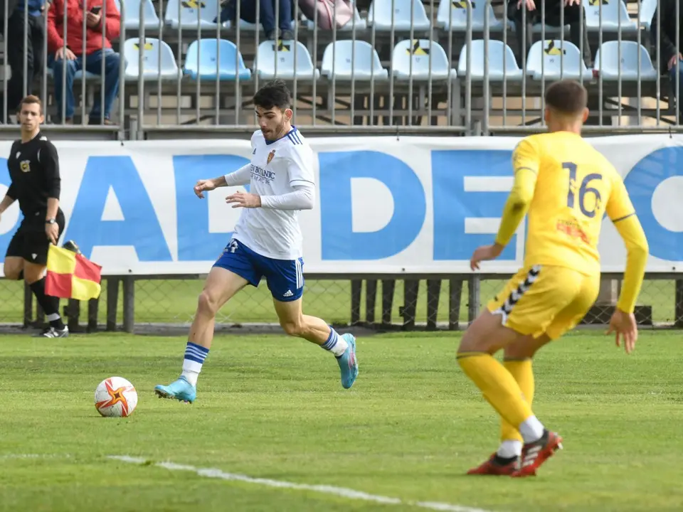 Miguel Puche conduce el bal&oacute;n en el partido frente al CD Robres, disputado en la Ciudad Deportiva. | Foto: RZ
