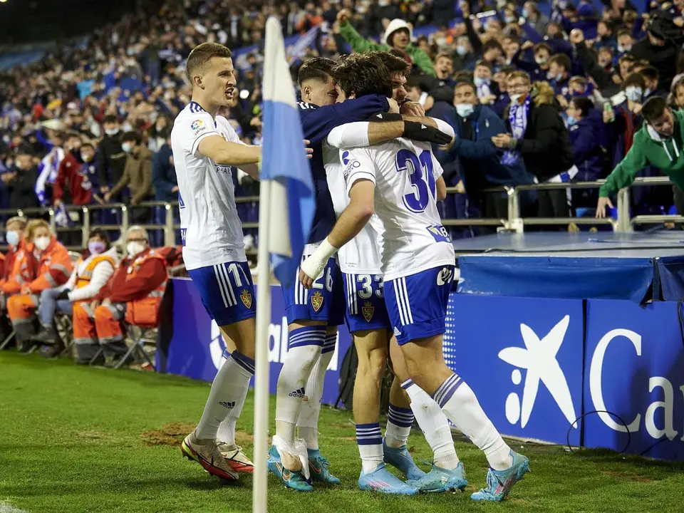 Jugadores del Real Zaragoza se abrazan en La Romareda en la celebraci&oacute;n de un gol. | Foto: RZ