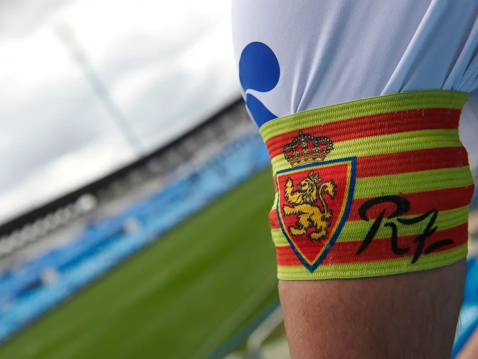 El brazalete del Real Zaragoza, con La Romareda de fondo. | Foto: RZ