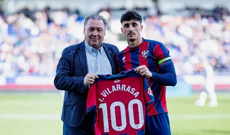 El presidente, Agust&iacute;n Lasaosa, entrega la camiseta conmemorativa de sus 100 partidos con el Huesca al lateral Ignasi Vilarrasa en febrero de 2025. Foto: SD Huesca