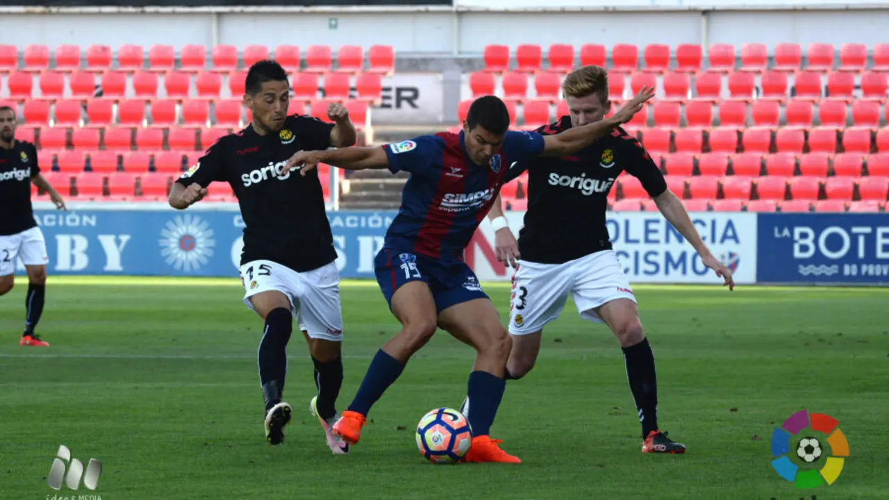 Alexander Gonz&aacute;lez lucha por un bal&oacute;n ante dos jugadores del N&agrave;stic | Foto: La Liga