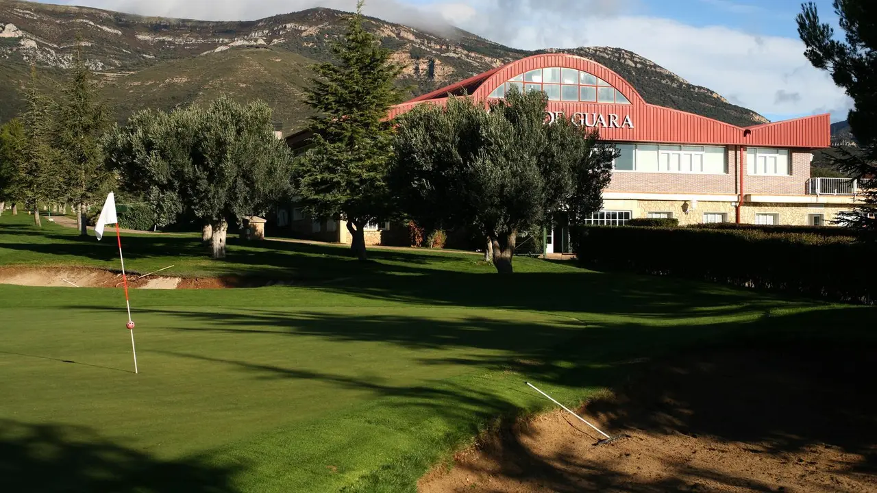 Vista de uno de los hoyos del Golf Guara con el edificio de la instalaci&oacute;n al fondo de la imagen. Foto: Golf Guara