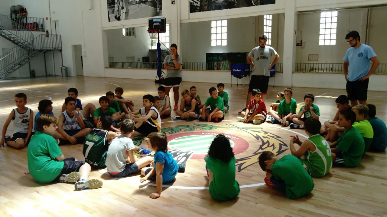 Los ni&ntilde;os del campus del CB Pe&ntilde;as atienden a las explicaciones de sus entrenadores. | Foto: CB Pe&ntilde;as