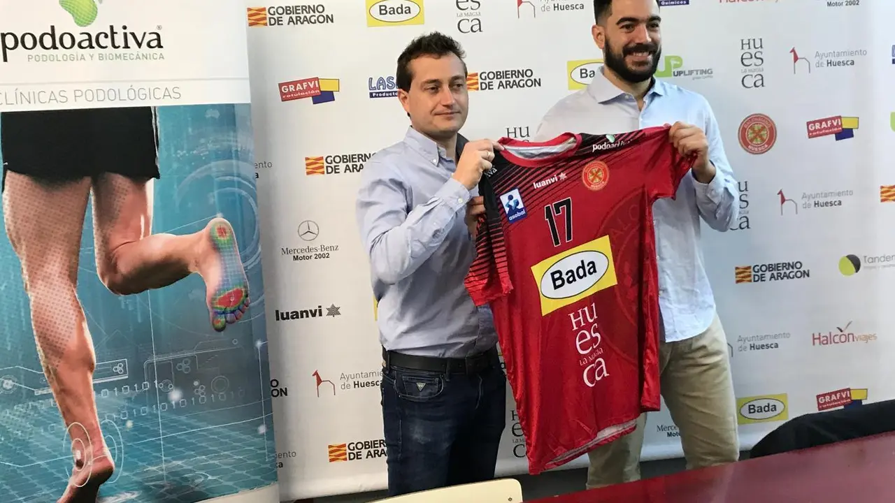 Javier Alfaro y Gonzalo Carr&oacute; sostienen la camiseta del pivote del Bada Huesca. Foto: BM Huesca