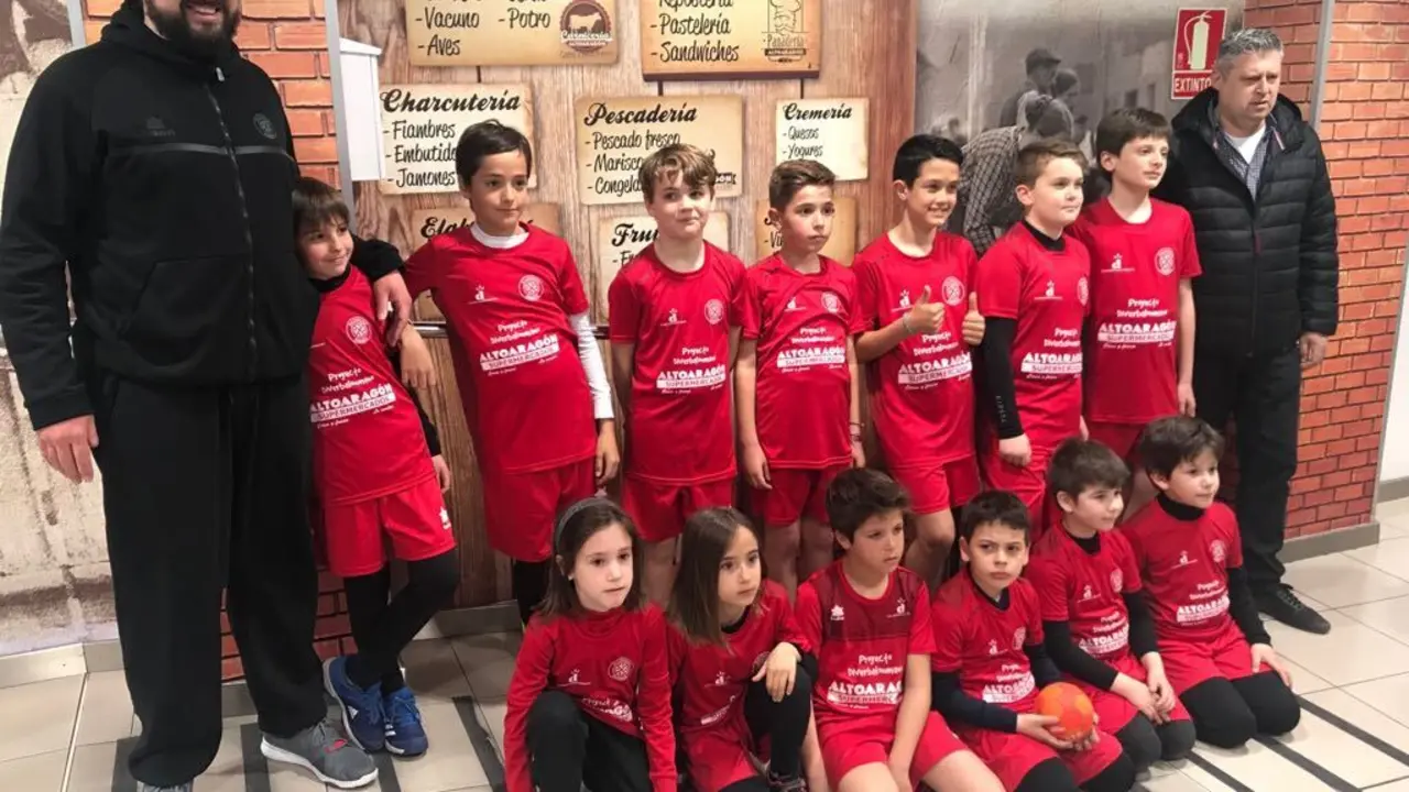 A la izquierda N&eacute;stor Oliva entre nador de Diverbalonmano con varios de los jugadores de este programa ya la derecha, Ralf Bernhard. Foto: Sporthuesca 