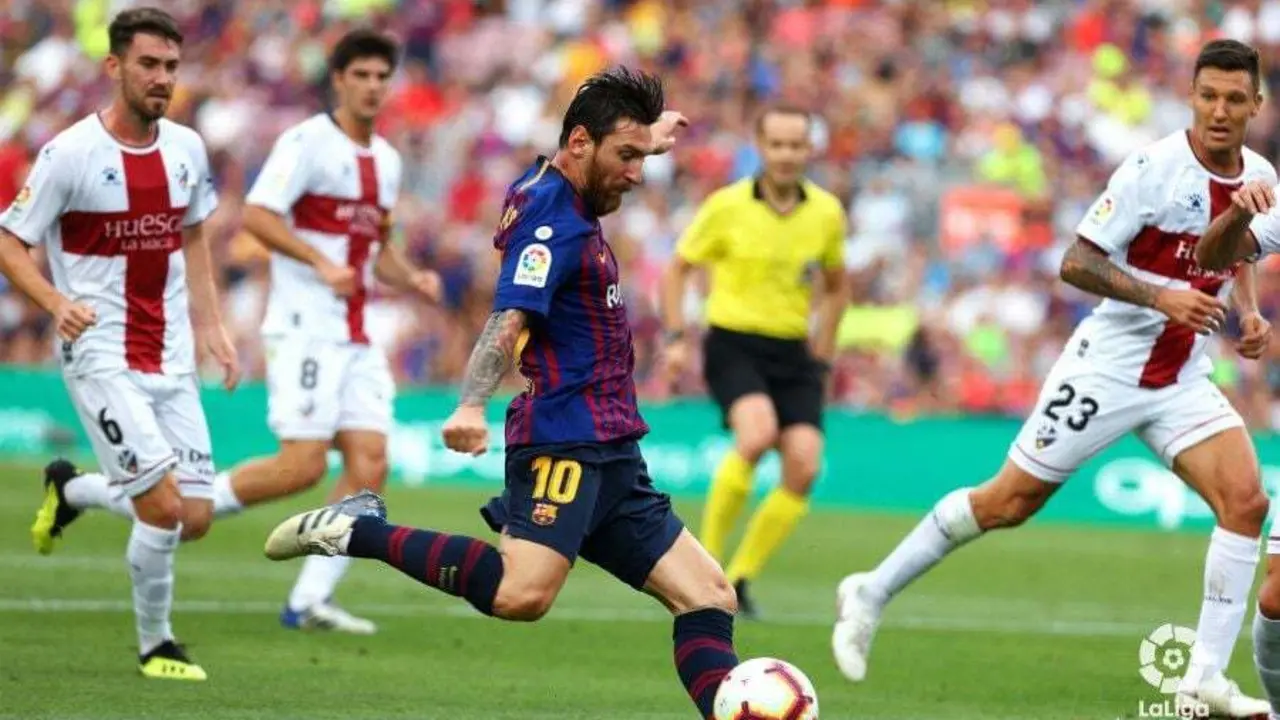 Messi ante la atenta mirada de los jugadores del Huesca | Foto: LaLiga