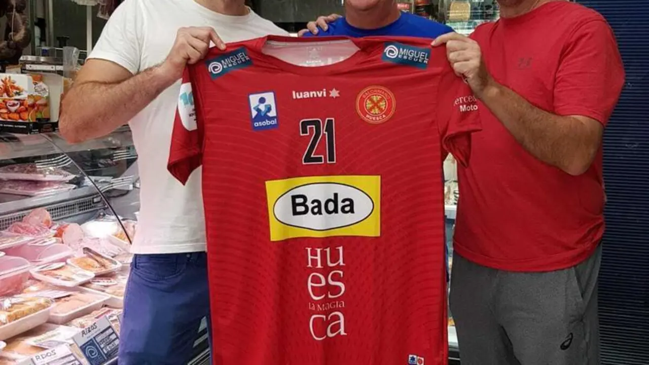 Oier, Miguel Escuer y Nolasco posan sonrientes con la camiseta del jugador. Foto: BM Huesca