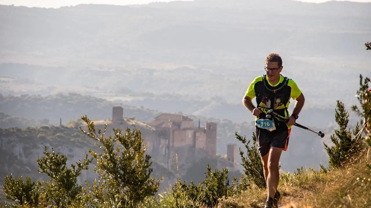Un corredor de la Ultra Trail Guara Somontano con la impresionante Colegiata de Alquezar al fondo de la imagen. Foto: Jos&eacute; Miguel Mu&ntilde;oz