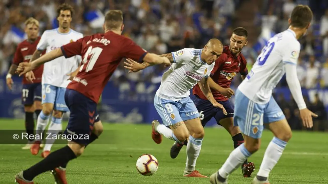 Pombo intenta conducir el bal&oacute;n ante los jugadores de Osasuna. | Foto: Tino Gil, Real Zaragoza