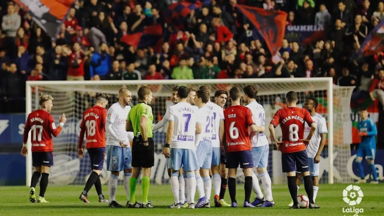 Jugadores de ambos equipos rodean al colegiado del encuentro en pleno choque | Foto: LFP