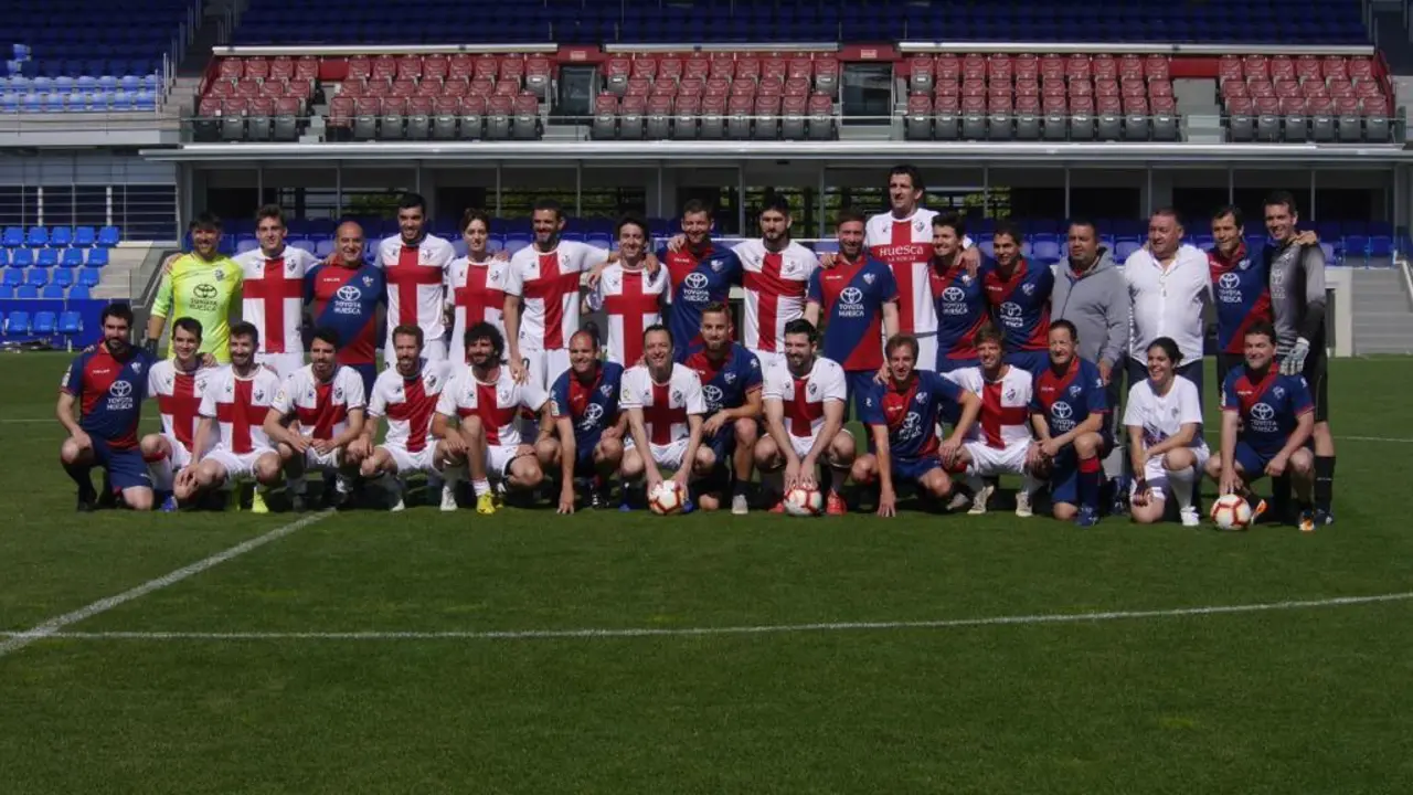 Foto de los jugadores previa al partido. De azulgrana, la prensa. Con la cruz, el staff del club. | Foto: SDHuesca