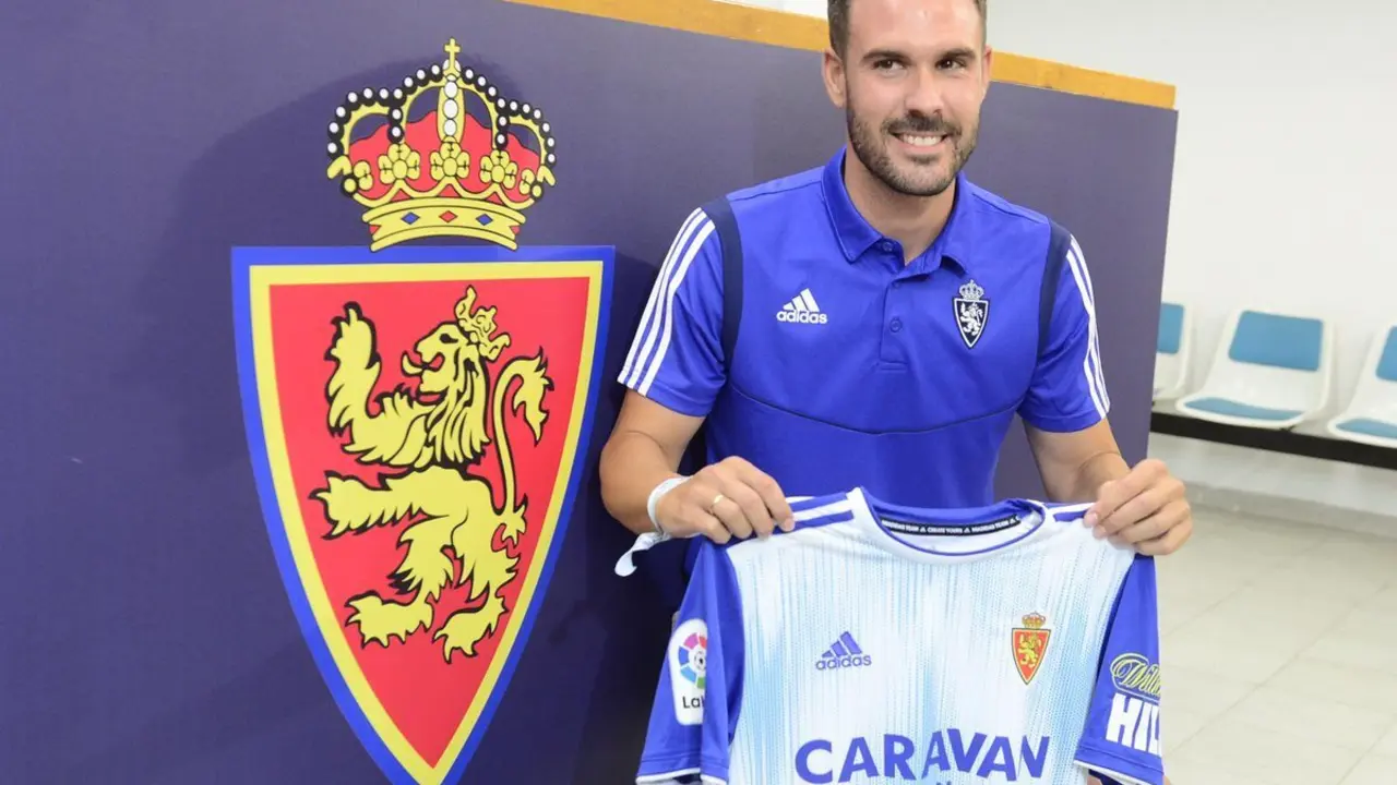 El nuevo jugador blanquillo posa junto al escudo. Foto: Real Zaragoza
