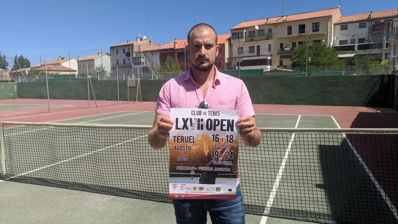 Francisco Quesada, director del Open de Tenis Ciudad de Teruel posa con un cartel del torneo. | Foto: Isabel Traver