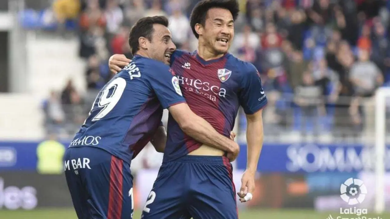 Pedro L&oacute;pez abraza a Okazaki tras el gol de japon&eacute;s que enjuag&oacute; para el Huesca el tanto conseguido por el Extremadura. Foto: LaLiga