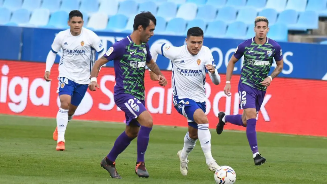 Juanjo Narv&aacute;ez pelea un bal&oacute;n ante los centrales del M&aacute;laga CF. Foto: Real Zaragoza