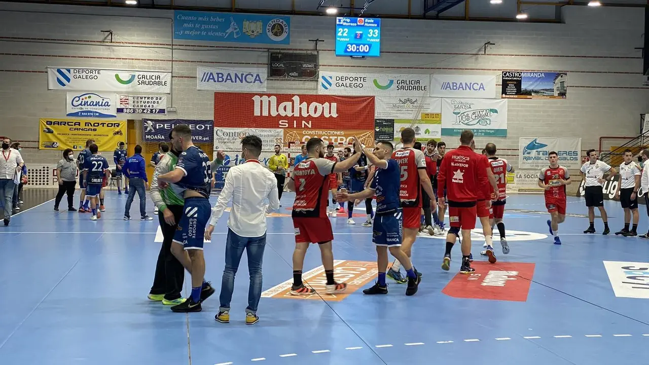 Los jugadores del Cangas y el Bada Huesca se saludan al t&eacute;rmino del encuentro sobre la pista de O'Gata&ntilde;al. Foto: Cangas