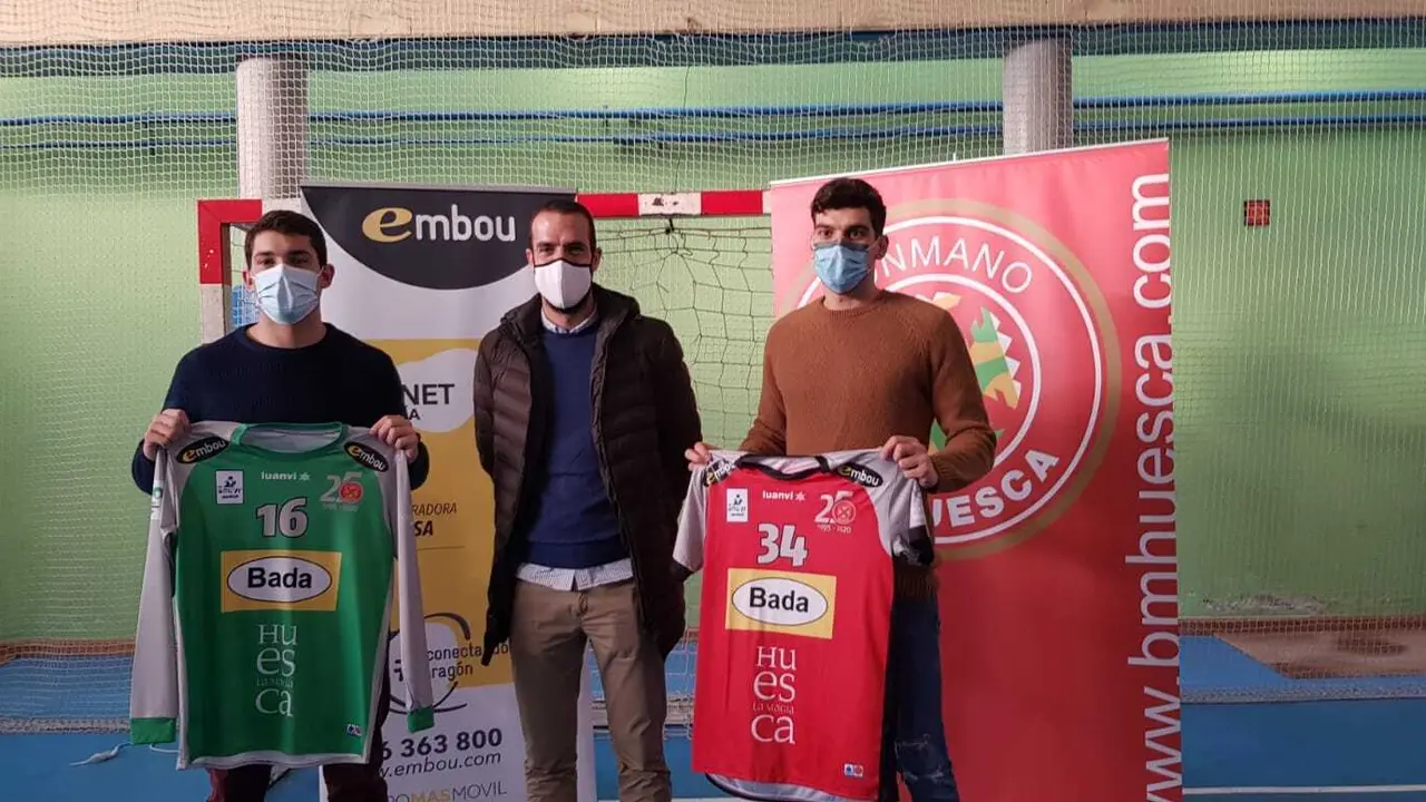 Jorge Broto y Miguel Malo sostienen sus camisetas con el responsable de marketing de Embou, Eti&eacute;n Aldea. Foto: BM Huesca