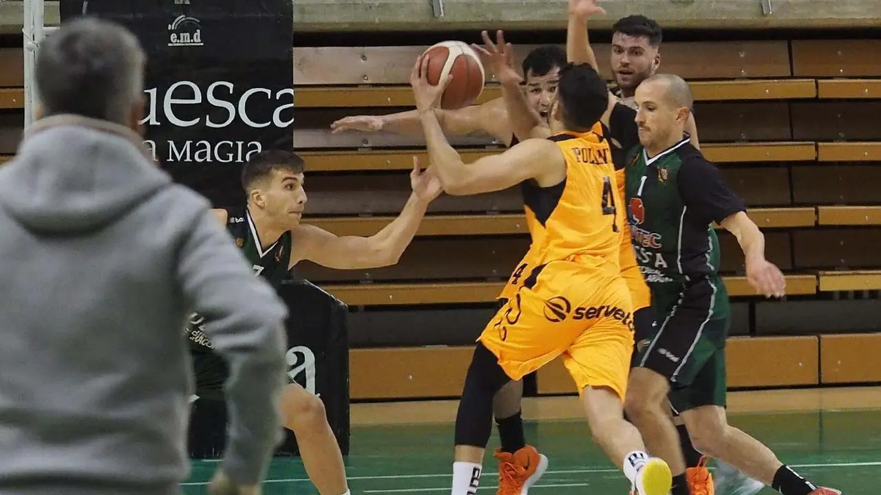 Los jugadores de Levitec Huesca protegen su aro en el partido que ganaron a Lleida. Foto: C.Pascual