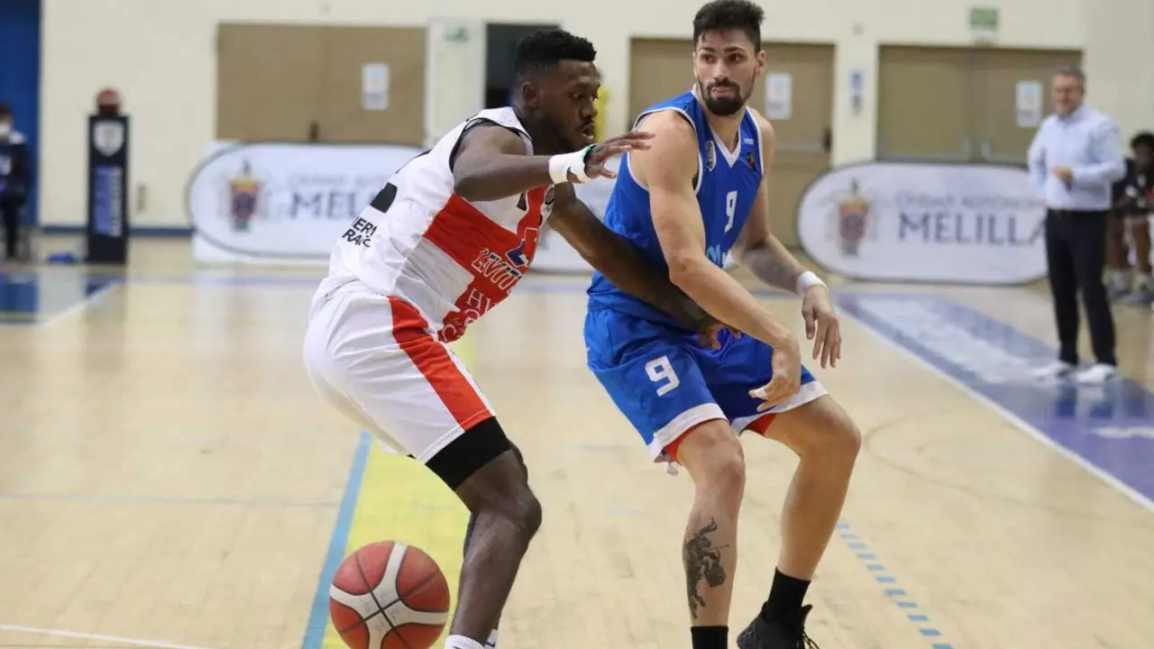 Mike Moore, en una acci&oacute;n defensiva en el partido contra Melilla y con &Oacute;scar Lata al fondo. Foto: Melilla Sport Capital