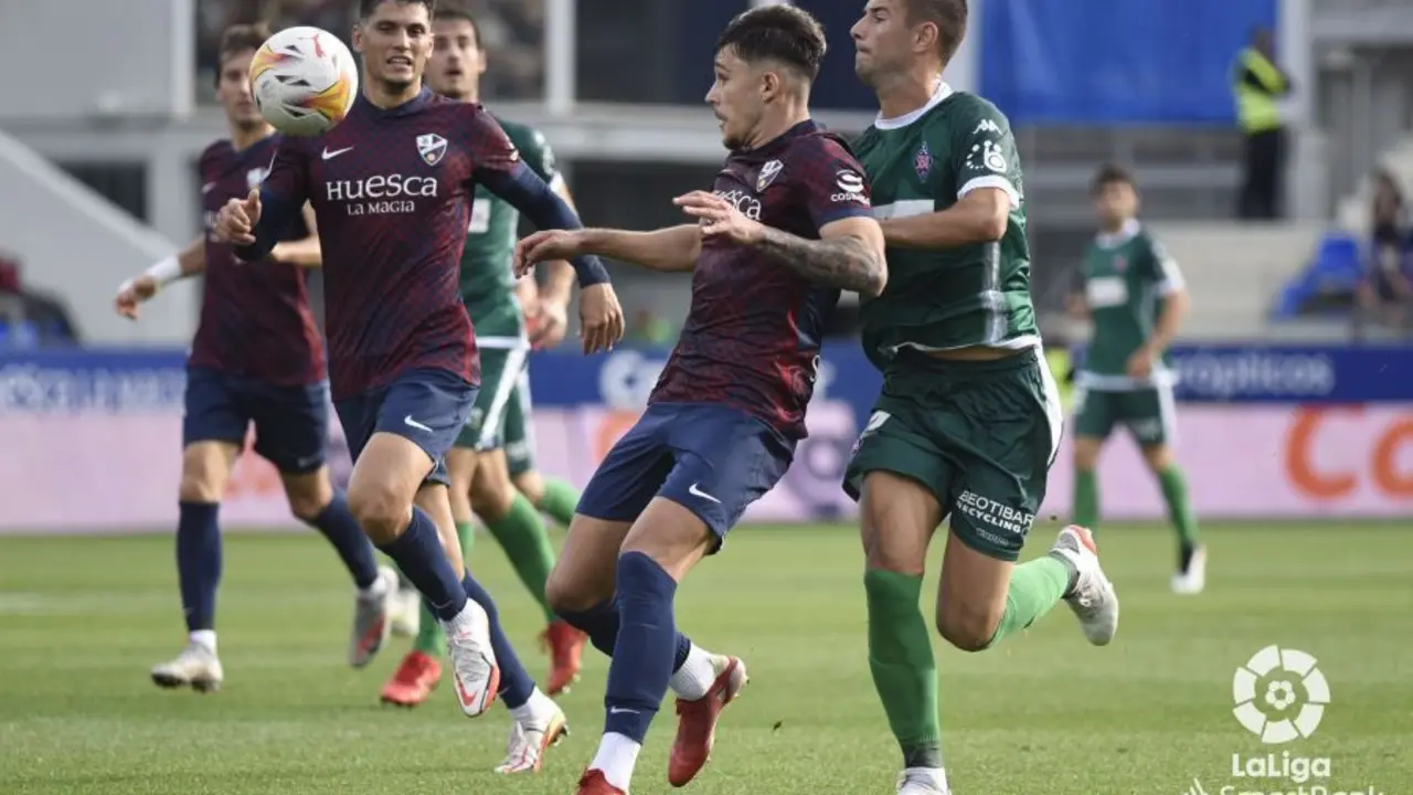 Ratiu, en el Huesca - Almer&iacute;a, protege el bal&oacute;n ante un jugador visitante.
