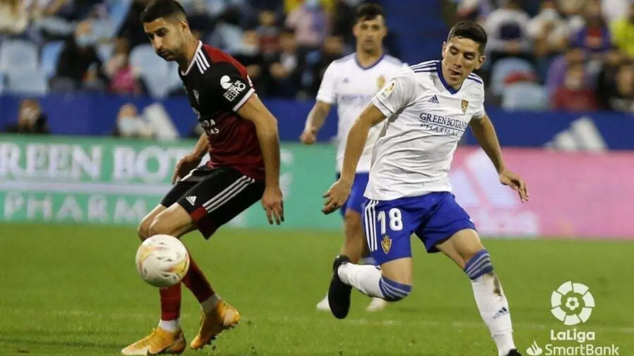 Fran G&aacute;mez pelea un bal&oacute;n en la banda de La Romareda. Al fondo, Nano Mesa vigila la jugada | Foto: La Liga