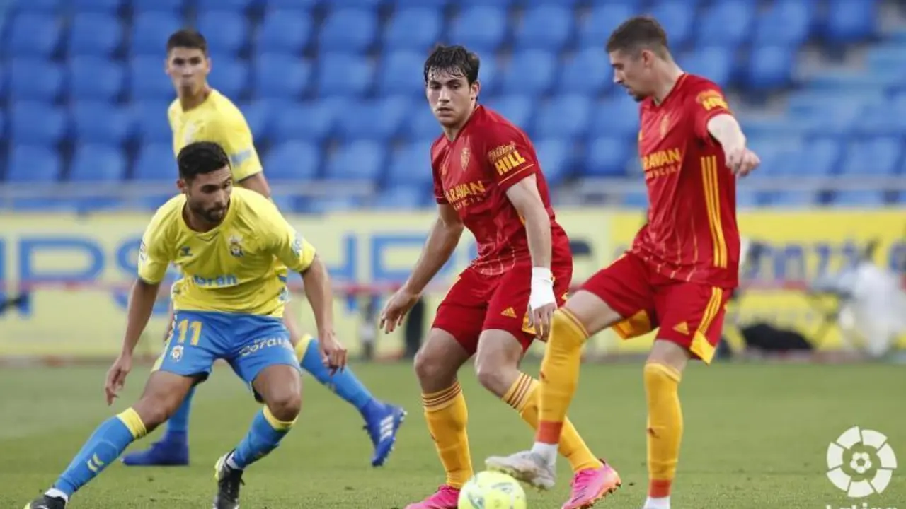 Benito pelea un bal&oacute;n con Zanimacchia ante la mirada de Iv&aacute;n Az&oacute;n en un lance del &uacute;ltimo Las Palmas-Real Zaragoza. | Foto: Real Zaragoza