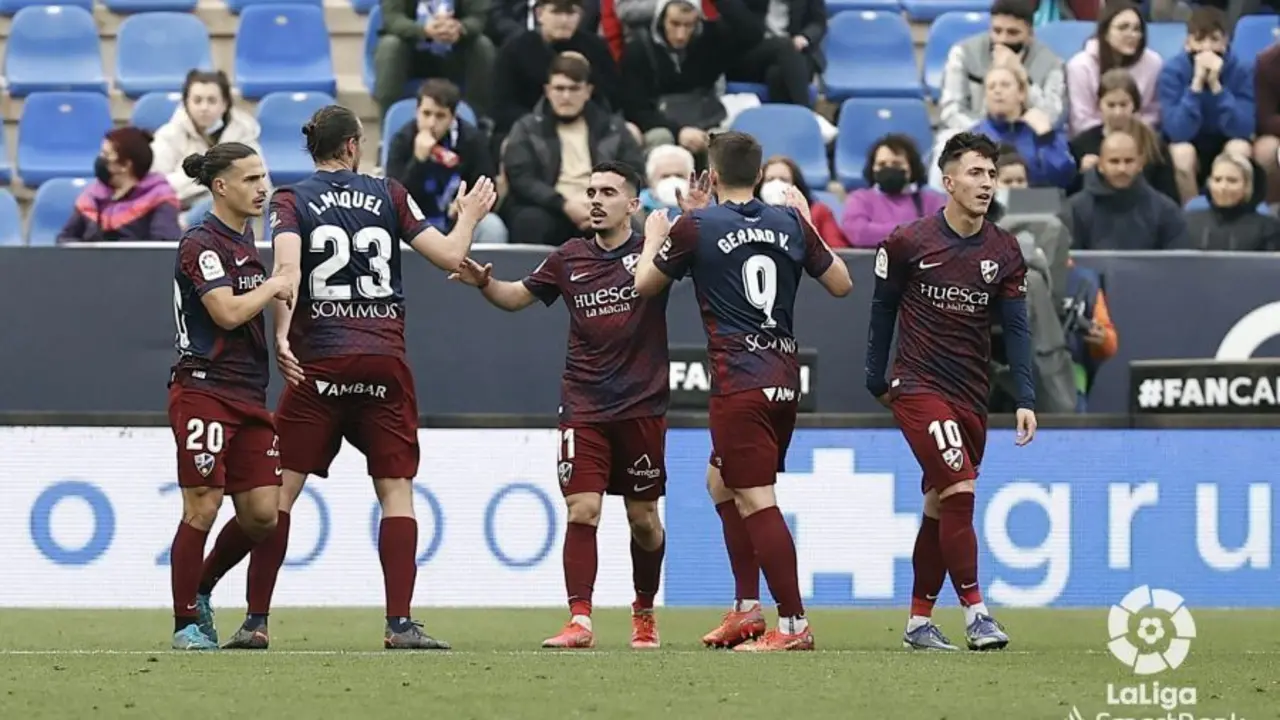 Los jugadores del Huesca de abrazan tras anotar un gol al M&aacute;laga. | Foto: LaLiga