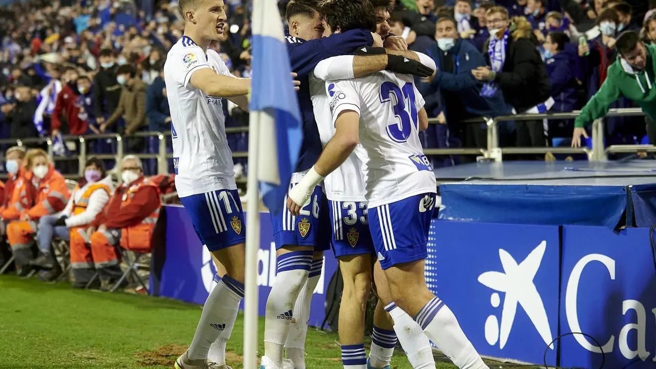 Jugadores del Real Zaragoza se abrazan en La Romareda en la celebraci&oacute;n de un gol. | Foto: RZ