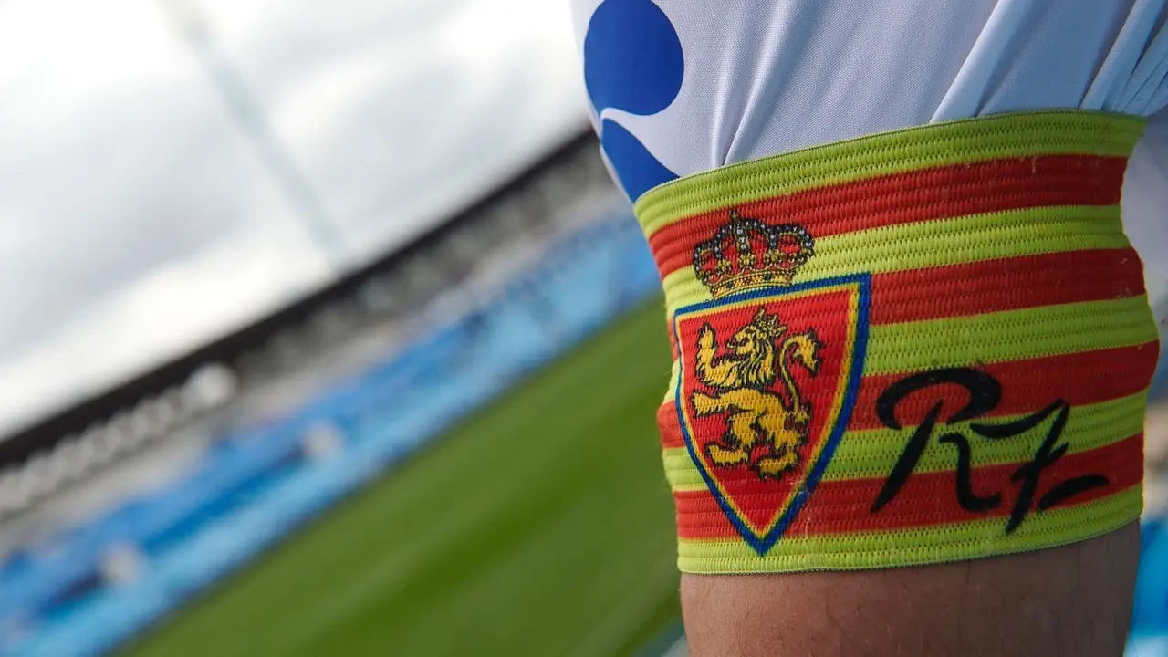 El brazalete del Real Zaragoza, con La Romareda de fondo. | Foto: RZ