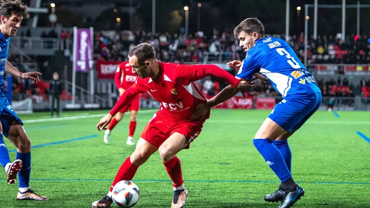 Un futbolista del conjunto local trata de zafarse de Julen Hualde, jugador del CD Teruel. | Foto: Terrassa FC