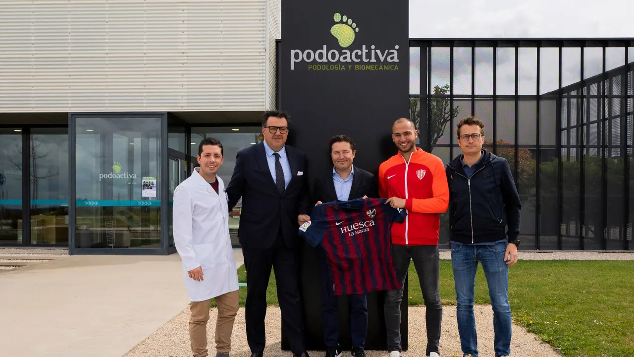 El presidente de Podoactiva sujeta una camiseta del Huesca entre Manolo Torres y J&egrave;r&egrave;my Blasco. Foto: Cedida
