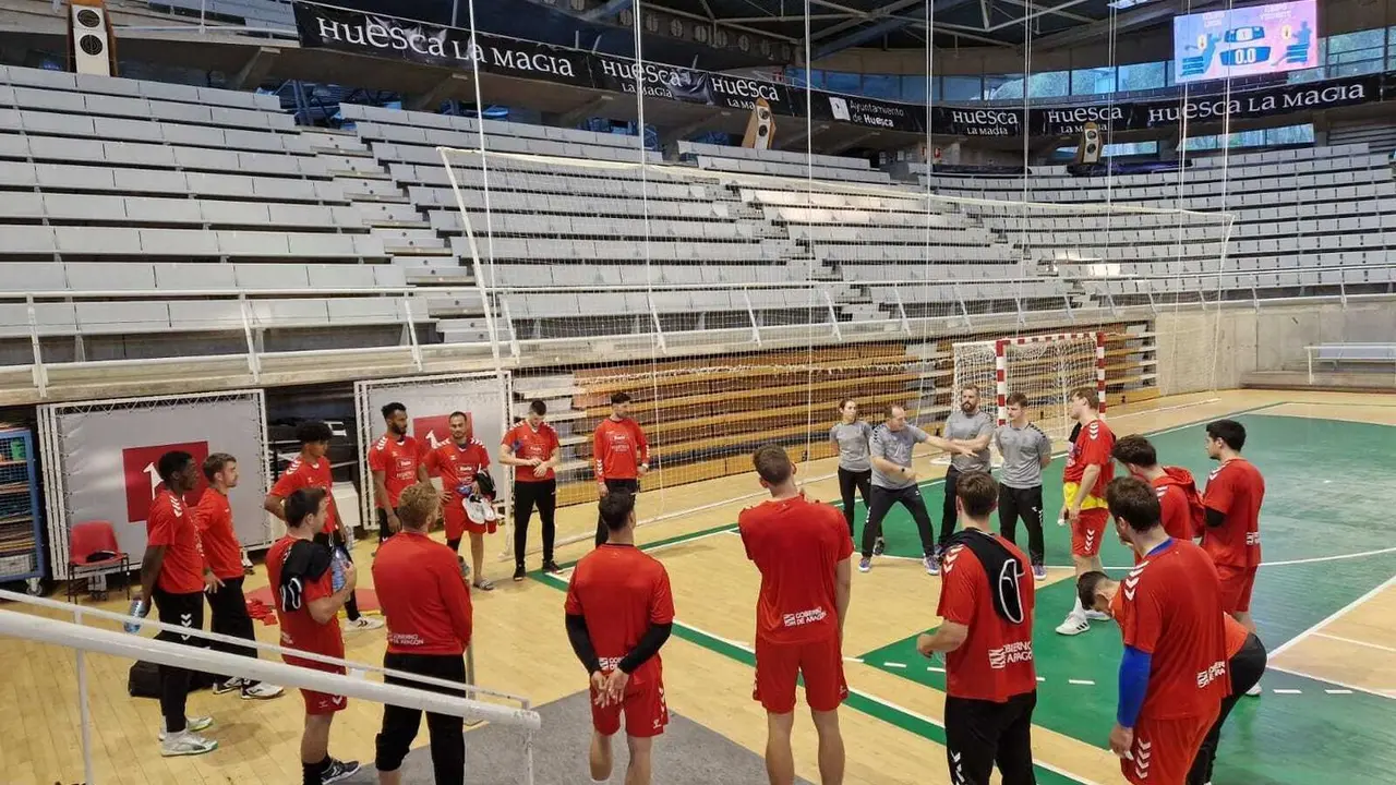 Nolasco, tras un entrenamiento de esta semana, explica a jugadores del Bada Huesca cuestiones sobre Torrelavega. Foto: Sportaragon