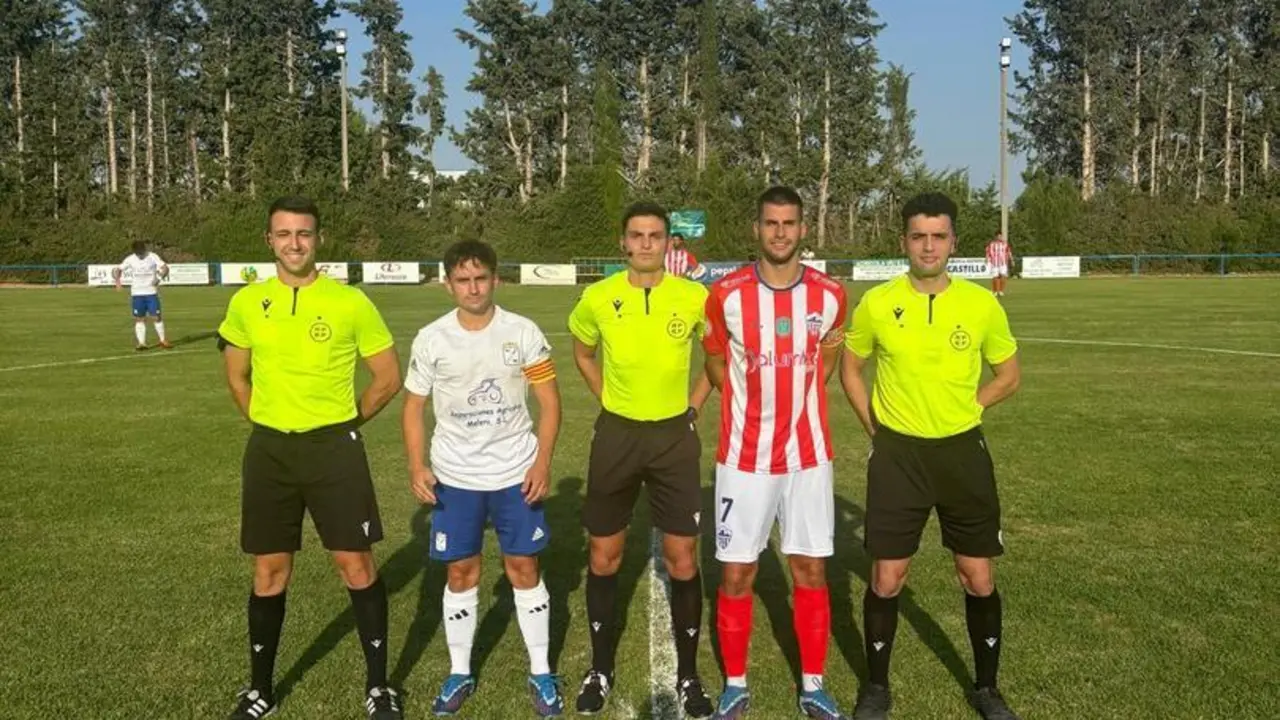 Los capitanes y el cuerpo arbitral antes del choque.