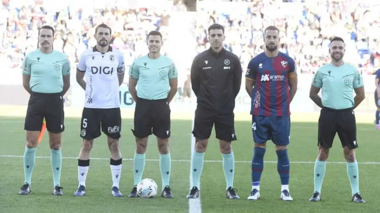 Los capitanes de Huesca y Burgos posan con los colegiados antes del encuentro / LFP