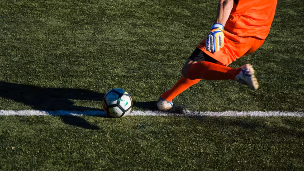 Hombre pateando la pelota de f&uacute;tbol en el campo. Foto: Edoardo Busti (@phoedobus)