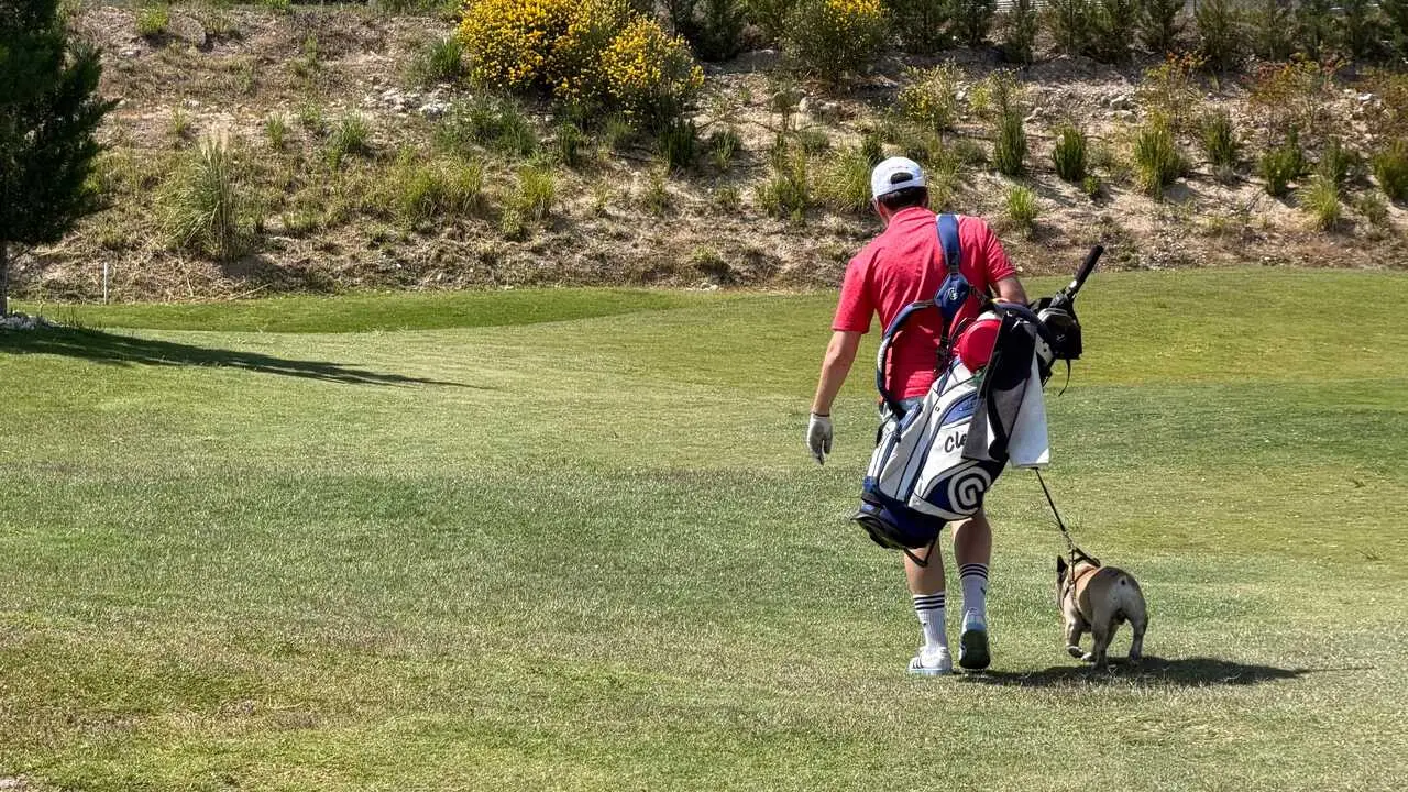 Golfista junto a su perro. Fotograf&iacute;a: Arcosur Golf.