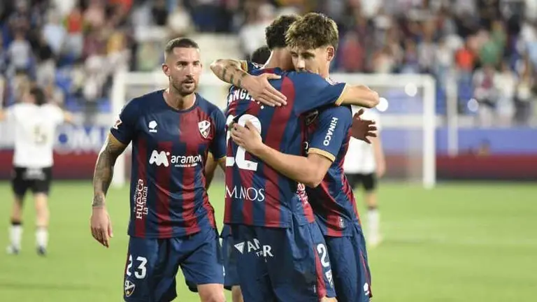 Jugadores de la SD Huesca abraz&aacute;ndose en la victoria ante el Burgos / LaLiga