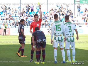El colegiado amonesta a un jugador en el partido Huesca-Córdoba | Foto: C.Pascual