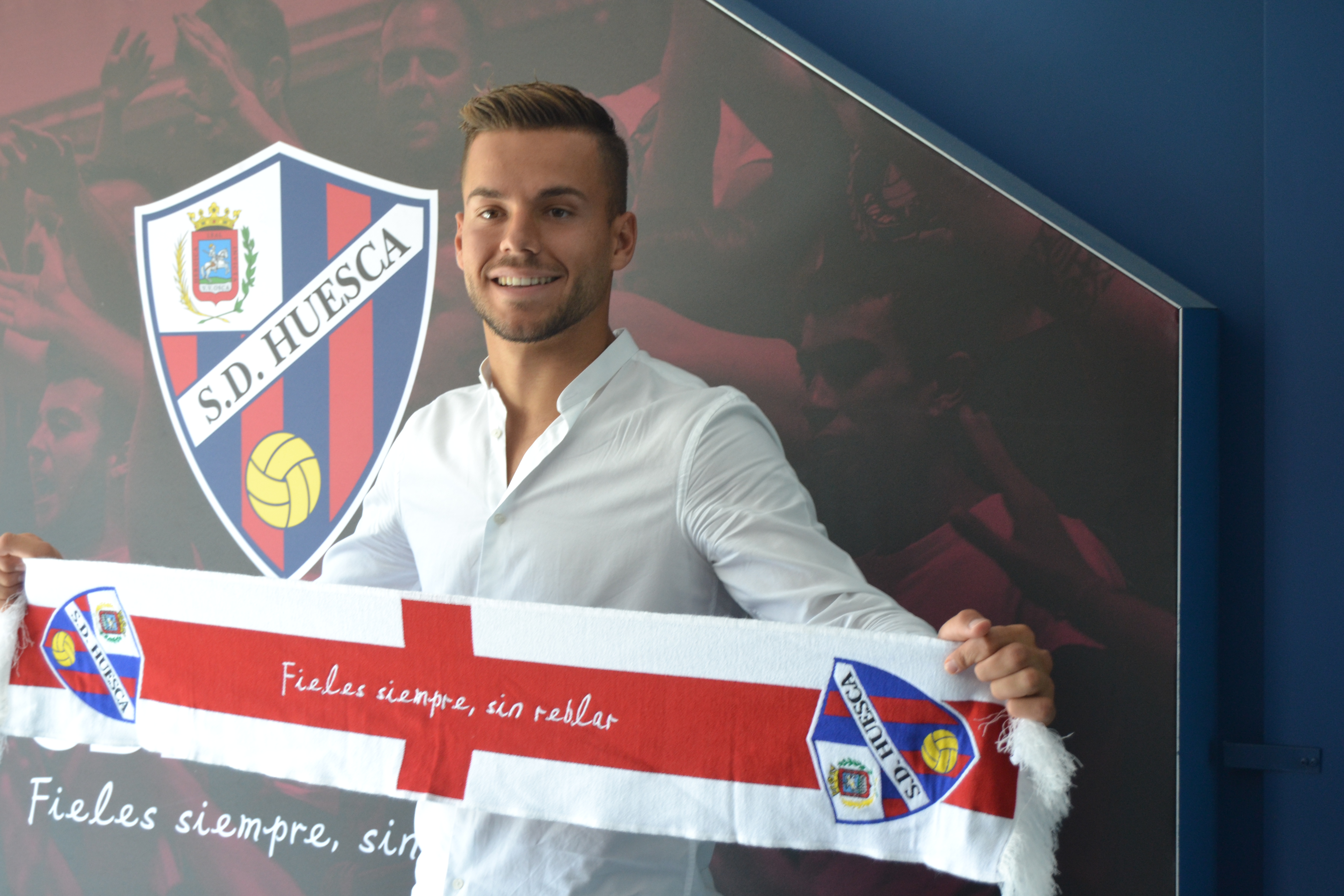 El nuevo portero el Huesca Álvaro Fernández posa con la bufanda del Huesca en el túnel de acceso al campo. Foto: Sportaragon