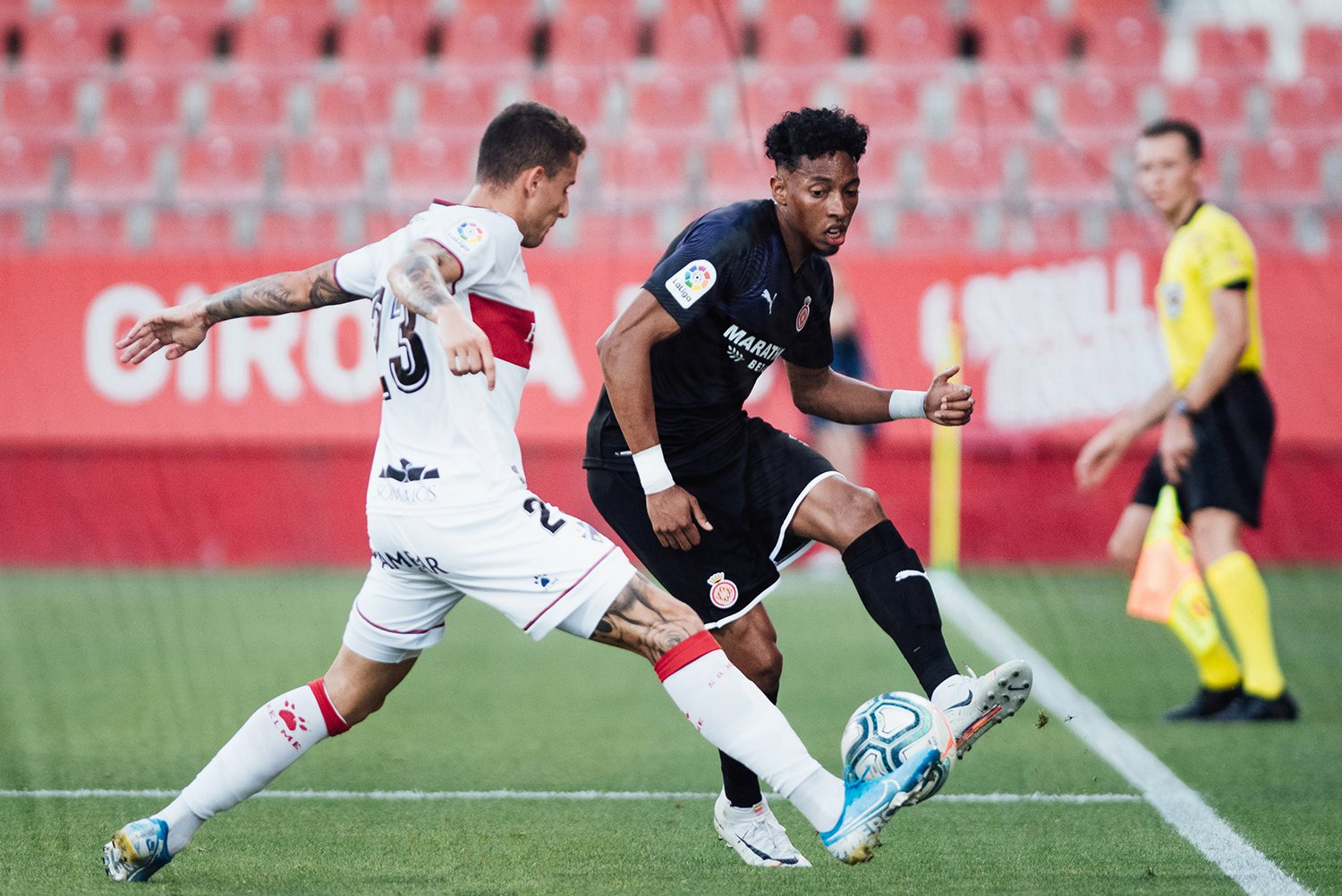 Girona y Huesca ya se vieron las caras en pretemporada. En la imagen, Raba y Mójica dispután un balón | Foto: Girona CF